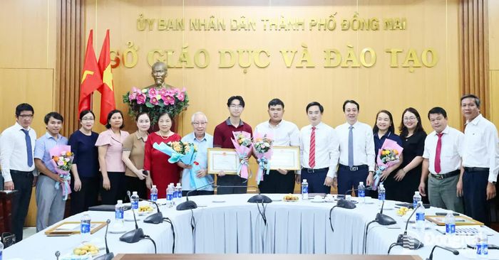 Ban giám đốc Sở Giáo dục và Đào tạo thành phố Đồng Nai chụp ảnh lưu niệm với 2 học sinh được tuyên dương, khen thưởng cùng người thân và thầy cô của các em đến chia vui. Ảnh: Công Nghĩa