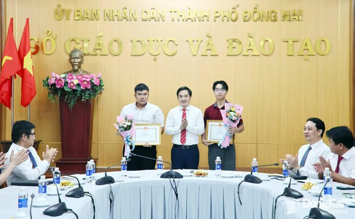 Tiến sĩ Đặng Anh Tuấn, Giám đốc Sở Giáo dục và Đào tạo trao giấy khen cho Đỗ Lê Tuấn Kiệt (bìa phải) và Lê Minh Quân (bìa trái). Ảnh: Công Nghĩa