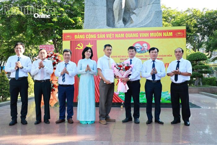 Đại diện Đảng ủy Các cơ quan Đảng tỉnh Khánh Hòa; lãnh đạo Đảng ủy, Ban Giám đốc Báo và Phát thanh, Truyền hình Khánh Hòa và Chi bộ Phòng Kỹ thuật - Công nghệ  trao quyết định, tặng hoa chúc mừng đảng viên mới Vũ Anh Thuyên.