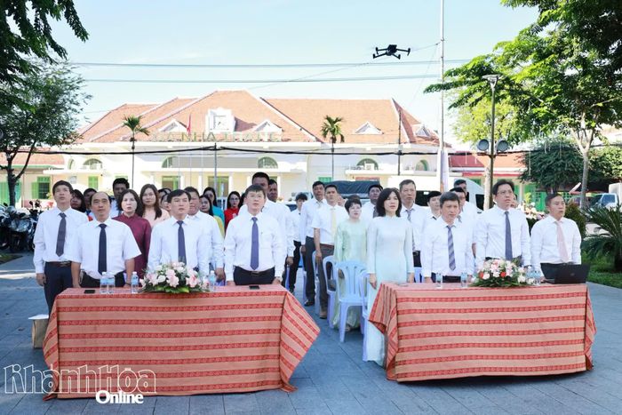 Các đại biểu, đảng viên, quần chúng ưu tú thực hiện nghi thức chào cờ.