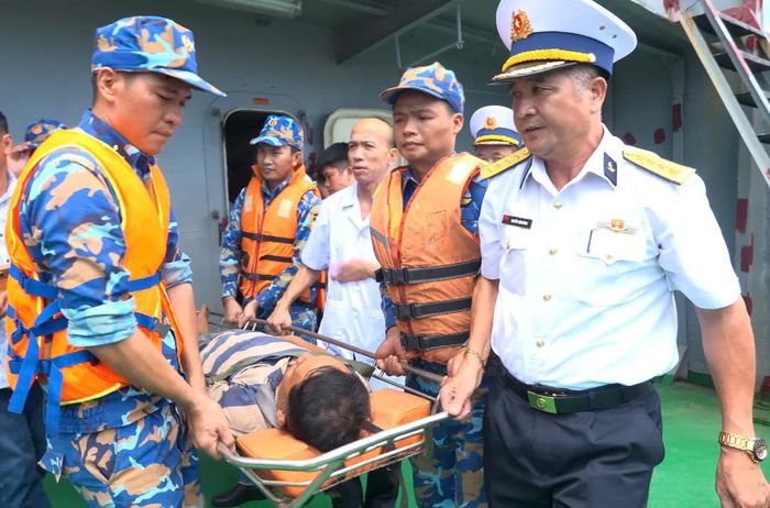 Đại tá Nguyễn Xuân Dũng cùng các chiến sĩ và lực lượng quân y đưa ngư dân Nguyễn Đức Quốc từ Tàu TS16 lên bờ.
