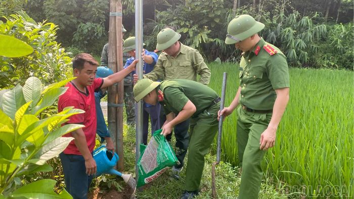 Lực lượng công an, quân sự hỗ trợ gia đình ông Cư A Páo dựng cột điện.