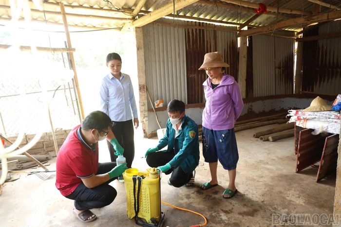 Viên chức Trung tâm Dịch vụ tổng hợp xã hướng dẫn người dân thực hiện kỹ thuật phun tiêu độc, khử trùng chuồng trại.