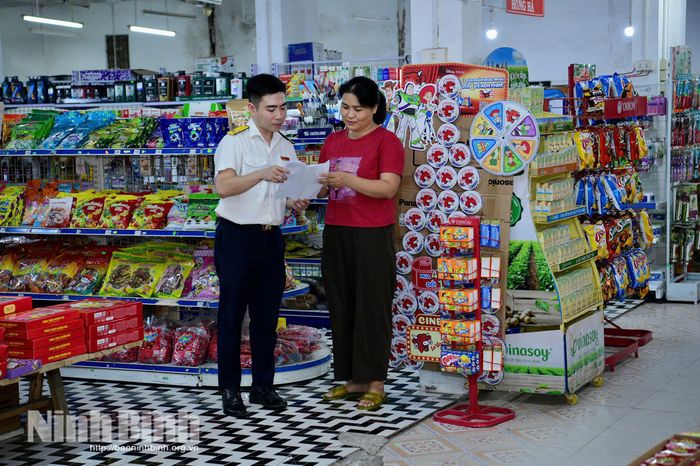 Cán bộ Thuế cơ sở 1 tuyên truyền chính sách mới tại một hộ kinh doanh phường Hoa Lư.