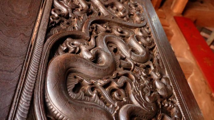 Hình tượng đôi rồng chầu Mặt Trời trên bộ cửa gỗ tại tiền đường chùa Phổ Minh.