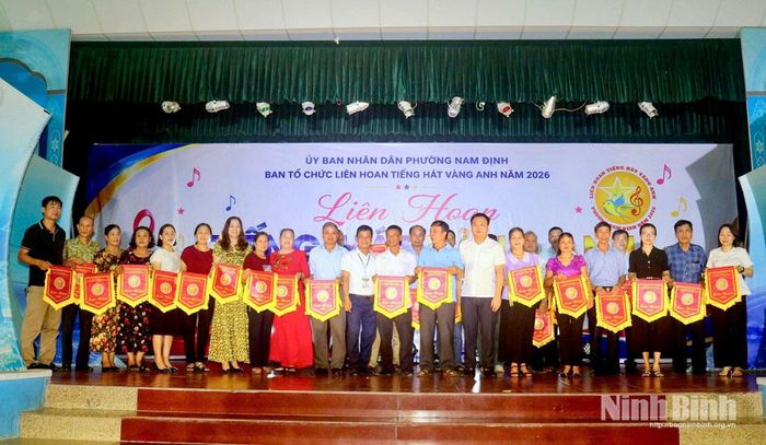 Ban tổ chức tặng cờ lưu niệm cho 32 đội văn nghệ tổ dân phố tham dự liên hoan.