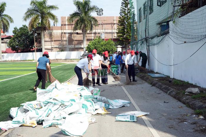 Các đại biểu và nhân dân tham gia vệ sinh môi trường.