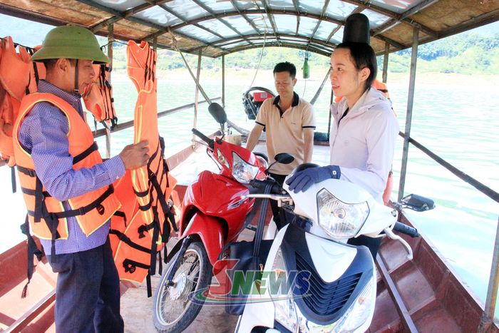 Chủ thuyền trang bị áo phao cho khách khi qua sông.