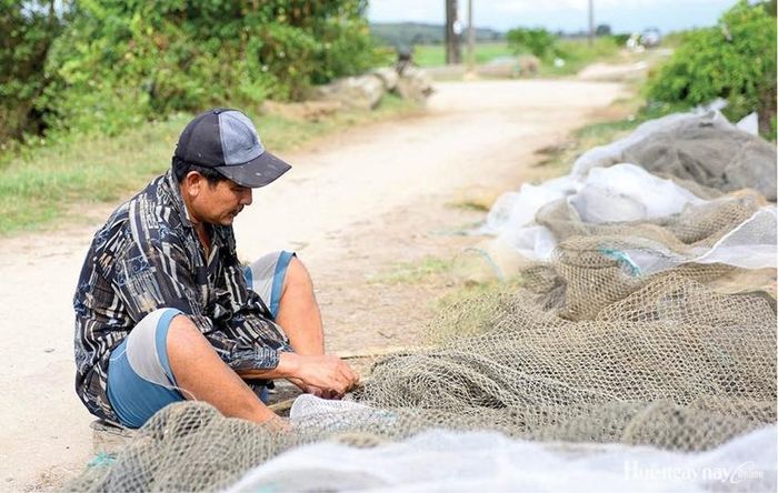  Ông Nguyễn Trí vá lưới để phục vụ đánh bắt.