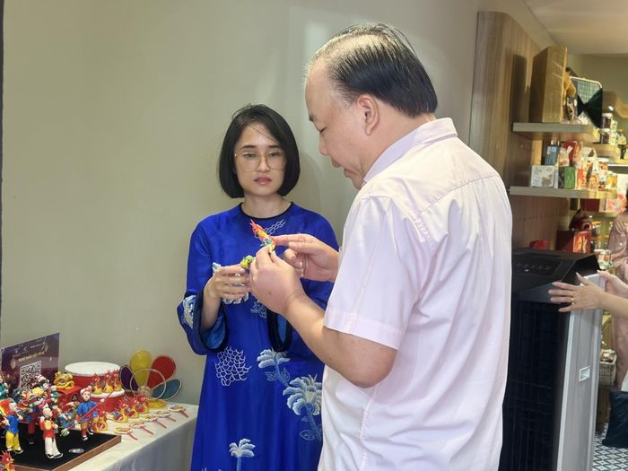 Phó Chủ tịch UBND phường Hoàn Kiếm và  Cục trưởng Cục phát triển thị trường trong nước tham quan các gian hàng.