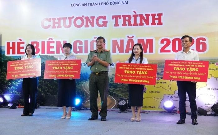 Đại tá Dương Văn Mạnh, Phó giám đốc Công an TP Đồng Nai trao bảng tượng trưng kinh phí hỗ trợ cho đại diện các trường học xã biên giới.