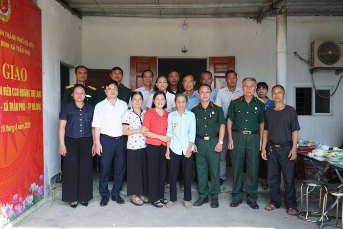 Các đại biểu tại lễ bàn giao chụp hình lưu niệm tại nhà của bà Hoàng Thị Lam. Ảnh: Minh Khiêm