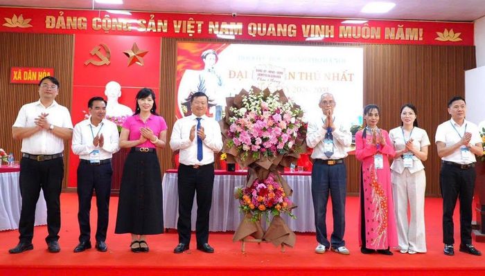Bí thư Đảng ủy, Chủ tịch HĐND xã Dân Hòa Mai Xuân Trường cùng các đồng chí lãnh đạo xã tặng hoa chúc mừng Đại hội. Ảnh: DH.