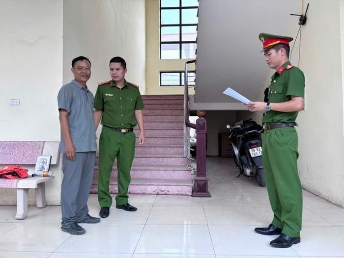 Cơ quan công an tống đạt Quyết định khởi tố bị can đối với Nguyễn Quang Thiều - (ảnh CABN).