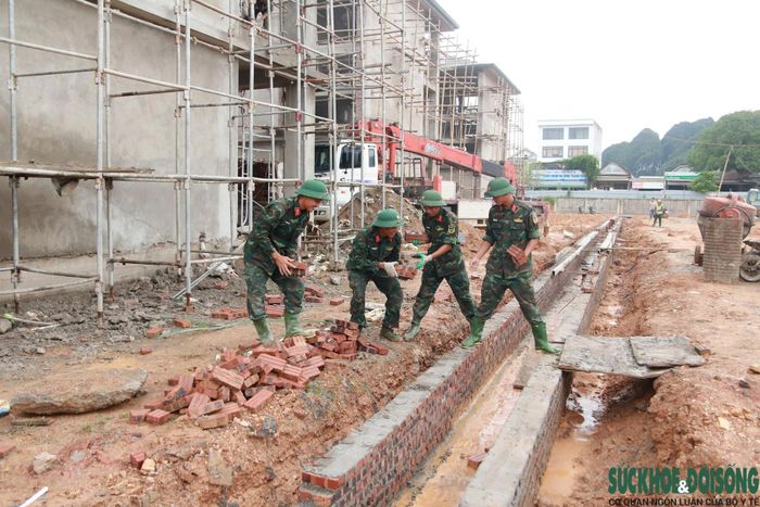 Các cán bộ, chiến sĩ được phân công thực hiện nhiều phần việc phù hợp tại công trường, từ vận chuyển vật liệu đến san gạt mặt bằng. (Ảnh: Song Hoàng)