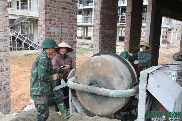 Bộ đội cùng công nhân nhà thầu vận chuyển vật liệu xây dựng đến các khu vực thi công. (Ảnh: Song Hoàng)