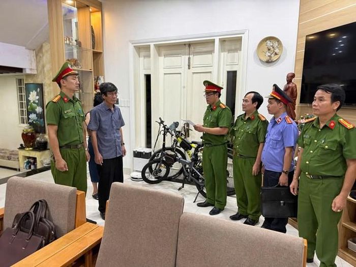 Cơ quan Cảnh sát điều tra đọc lệnh bắt bị can để tạm giam đối với ông Hà Xuân Hậu (người mang áo sơ mi xanh, đeo kính). Ảnh: Công an cung cấp.