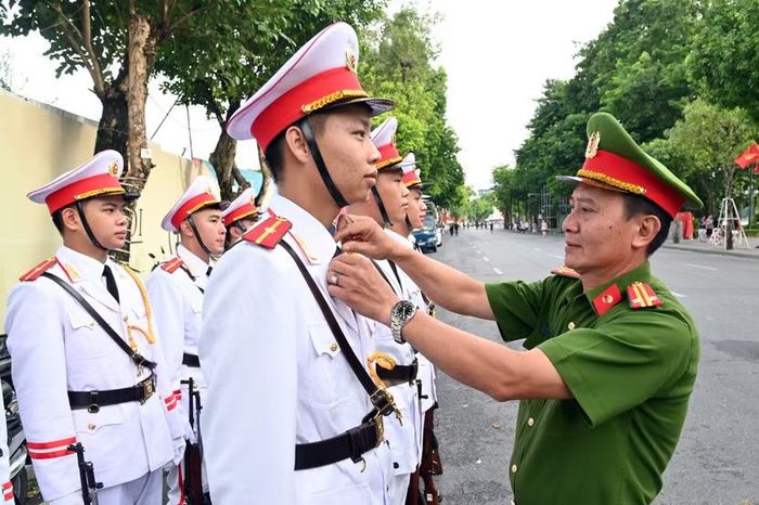 Cán bộ Đội Nghi lễ CATP Hà Nội chỉnh lại quân phục cho tiêu binh để đảm bảo từng nếp áo, caravat, hay đến chiếc cúc cũng phải đúng quy định