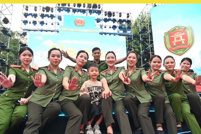 Em bé thích thú được chụp ảnh cùng dàn diễn viên là các nữ cán bộ Công an Thủ đô