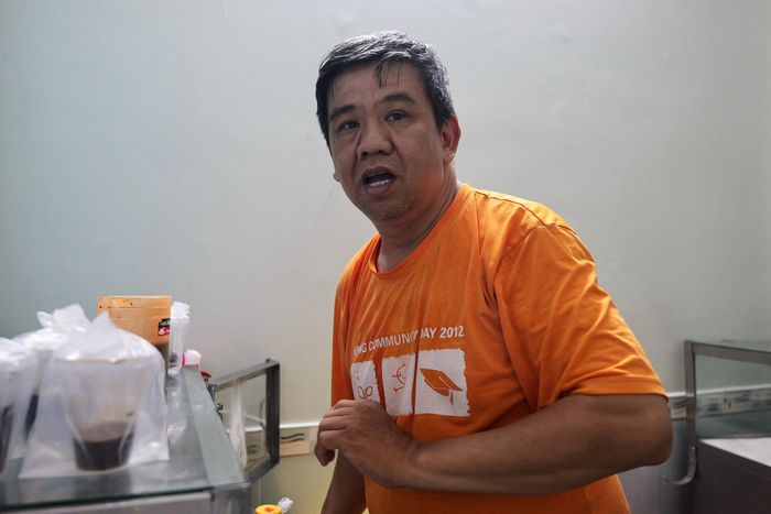  Ông Đạt hàng ngày chạy xe ôm, nay tạm gác để phụ giúp vợ chồng ông Huynh bán hàng.