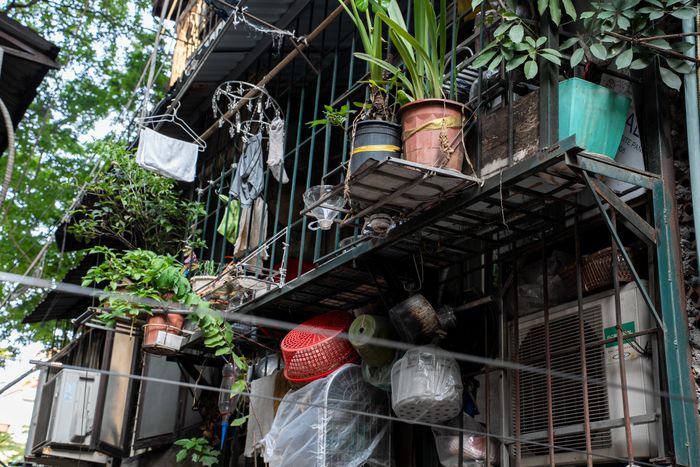 Hàng loạt ban công tại các tầng được người dân cơi nới bằng khung sắt, mái tôn và vật liệu tạm, tạo thành những phần diện tích mở rộng san sát nhau.