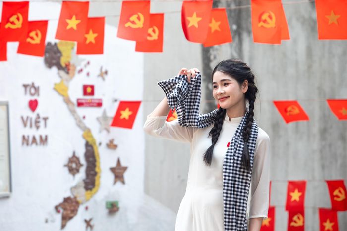 Nữ sinh chụp ảnh tại ngõ cờ đỏ sao vàng Hà Nội. Ảnh: Đinh Hà.