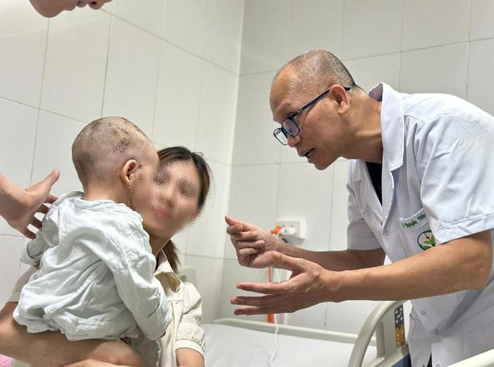 PGS.TS Nguyễn Hồng Hà, Trưởng khoa Phẫu thuật Hàm mặt - Tạo hình và Thẩm mỹ, thăm khám cho bệnh nhi sau phẫu thuật