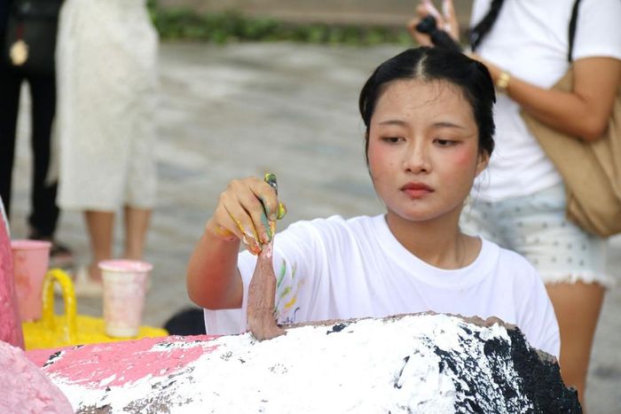 Tình nguyện viên tỉ mỉ sơm, trang trí các khối đá với mong ước góp phần làm đẹp thêm cho bờ kè biển Thương Chánh, phường Phan Thiết, tỉnh Lâm Đồng.