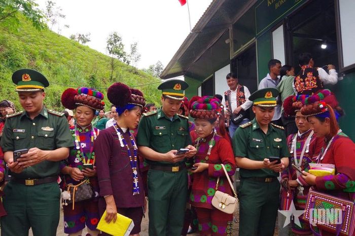 Cán bộ, chiến sĩ Đồn Biên phòng Vàng Ma Chải, Bộ đội Biên phòng tỉnh Lai Châu hướng dẫn bà con cài đặt ứng dụng trên điện thoại. Ảnh: BẰNG GIANG