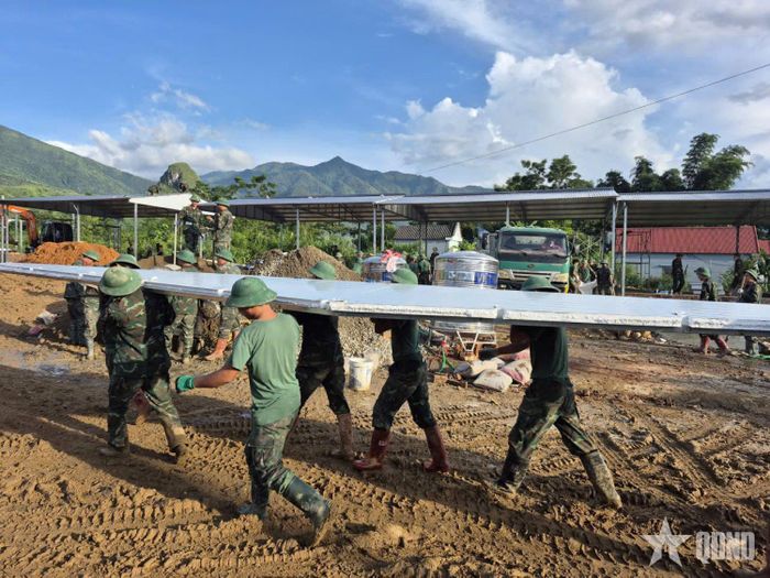 Cán bộ, học viên Học viện Hậu cần khẩn trương dựng nhà giúp dân vùng lũ. Ảnh: HẢI LONG 