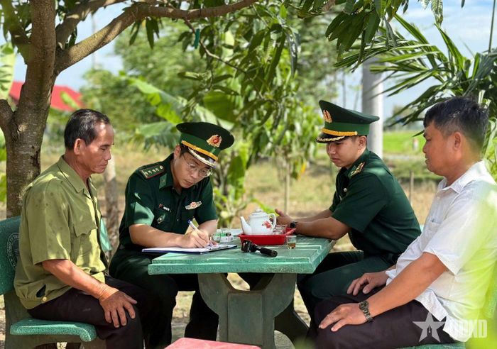 Đại úy Phạm Việt Tiến (thứ hai, từ trái sang) hướng dẫn người dân đăng ký tham gia tự quản đường biên, cột mốc và an ninh, trật tự khu vực biên giới.