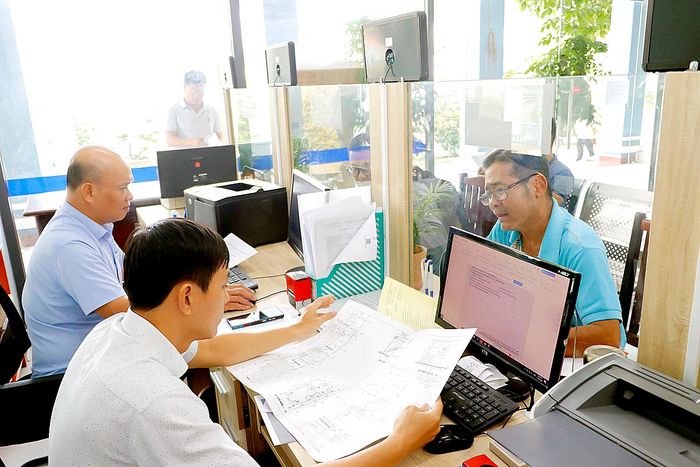 Cán bộ Trung tâm Phục vụ hành chính công phường An Phú Đông, TPHCM, hướng dẫn người dân thực hiện thủ tục về đất đai. Ảnh: NGÔ BÌNH