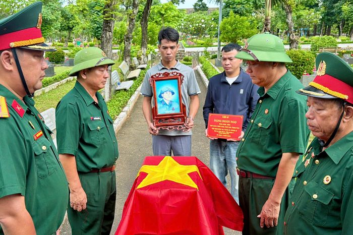  Nghi thức phủ Quốc kỳ lên hài cốt liệt sĩ Đặng Doãn Ngọ. Ảnh: HOÀNG HÙNG 