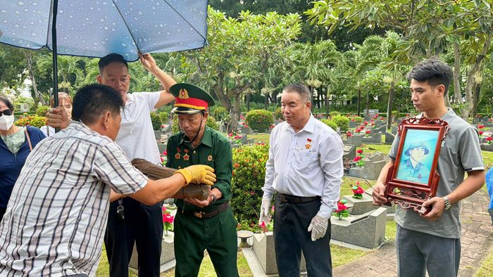  Hài cốt liệt sĩ Đặng Doãn Ngọ được chuyển giao cẩn trọng đến gia đình sau khi hoàn tất việc cất bốc. Ảnh: HOÀNG HÙNG 