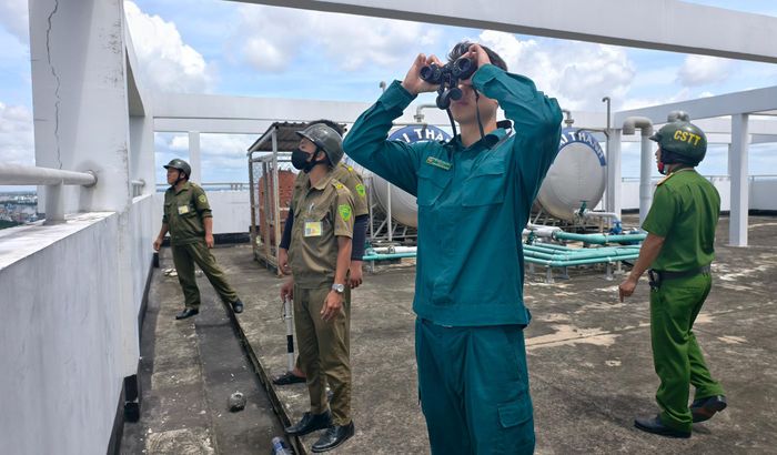  Công an phối hợp các đơn vị liên quan lập trạm quan sát tạm trên nóc chung cư để chủ động phát hiện diều hoặc vật thể bay không xác định gần sân bay Tân Sơn Nhất. Ảnh: NGUYỄN TÂN 