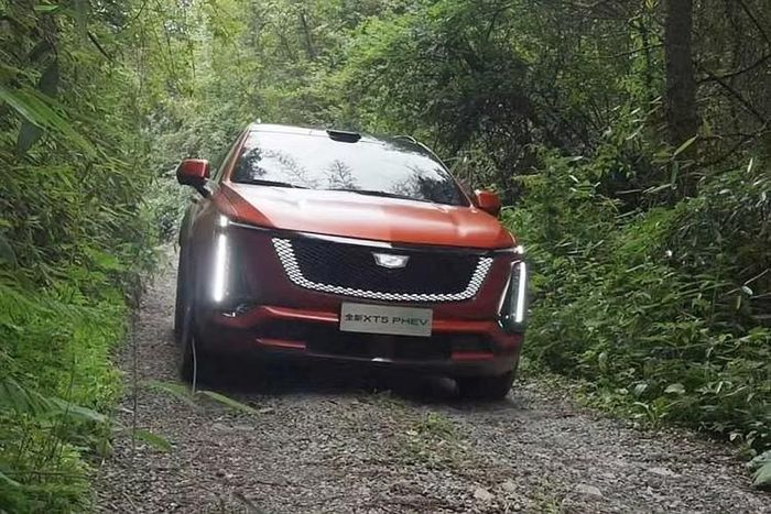 Mẫu xe SUV Cadillac XT5 PHEV 2026 mới ra mắt mang ngôn ngữ thiết kế đồng điệu với các dòng xe thuần điện mới nhất của hãng như Optiq, Lyriq và Vistiq. Phần đầu xe nổi bật với lưới tản nhiệt dạng khiên đen bóng tích hợp dải đèn viền chiếu sáng, kết hợp cùng cụm đèn pha đặt dọc đặc trưng.