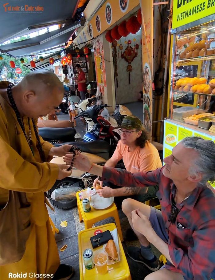 Ngay sau đó, người đàn ông lấy từ bát ra chiếc vòng đeo tay có đính hạt đeo cho du khách như một cử chỉ "ban phước".