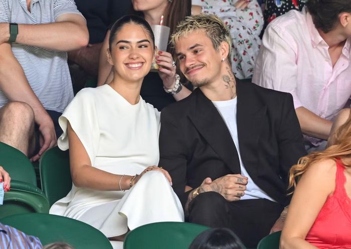 Kim Turnbull và Romeo Beckham trên khán đài Wimbledon ngày 29/6. Nữ DJ chọn đầm trắng phom suông, tay ngắn, kết hợp tóc búi gọn và trang sức mảnh. Cô ngày càng được chú ý khi xuất hiện liên tục cùng nhà Beck.