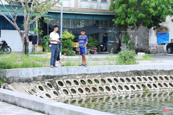Không có lan can nên việc người dân đứng sát mép hồ câu cá hay ngồi trên ghế đá sát hành lang tiềm ẩn nguy cơ trượt ngã, rơi xuống nước.