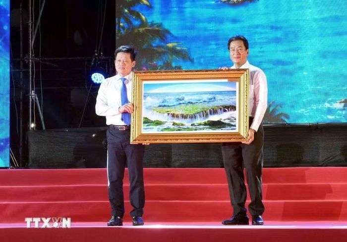 Phó Chủ tịch Thường trực UBND tỉnh Khánh Hòa Nguyễn Long Biên (bên phải) tặng quà lưu niệm đến lãnh đạo UBND tỉnh Quảng Trị. (Ảnh: Tá Chuyên/TTXVN)