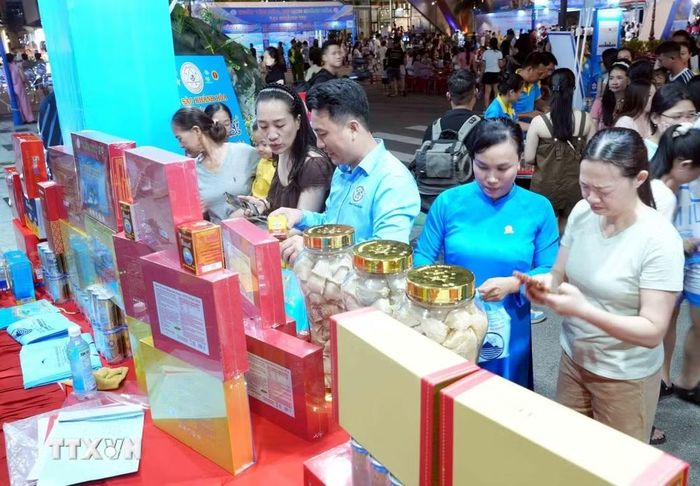Du khách tìm hiểu, mua sản phẩm Yến sào Khánh Hòa bên lề chương trình Khai mạc. (Ảnh: Tá Chuyên/TTXVN)