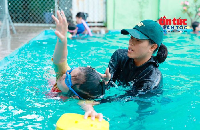 Giáo viên hướng dẫn các trẻ em các động tác cơ bản trong môn bơi lội.