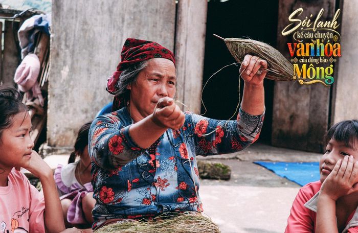 Các em nhỏ chăm chú theo dõi người lớn truyền dạy kinh nghiệm dệt vải lanh thủ công