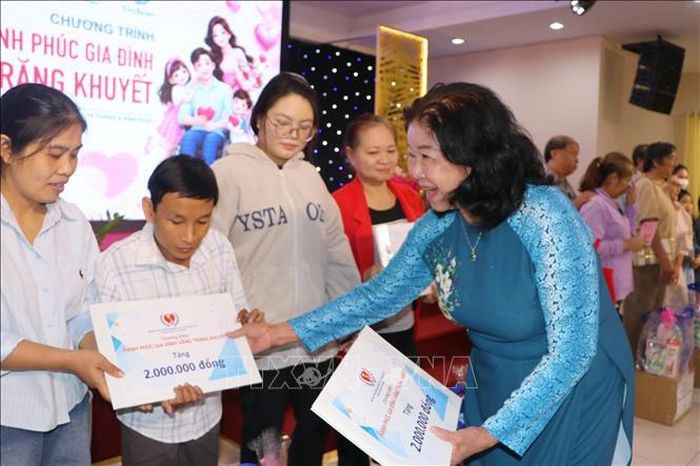 Bà Nguyễn Thị Bích Ngọc, Chủ tịch Hội Người khuyết tật và Trẻ mồ côi Thành phố Hồ Chí Minh tặng hoa và quà cho các gia đình người khuyết tật tiêu biểu tại chương trình.