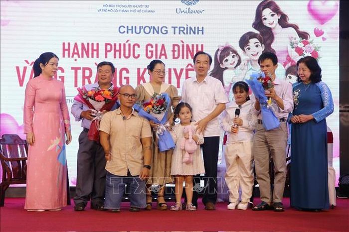 Ông Ngô Sách Thực, Chủ tịch Hội Người khuyết tật Việt Nam và bà Nguyễn Thị Bích Ngọc, Chủ tịch Hội Người khuyết tật và Trẻ mồ côi Thành phố Hồ Chí Minh tặng hoa và quà cho các gia đình người khuyết tật tiêu biểu tại chương trình.
