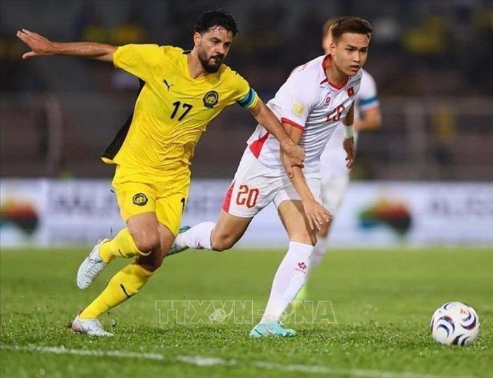 Bùi Hoàng Việt Anh (20 Việt Nam) nỗ lực cản phá pha đi bóng của cầu thủ số 17 Malaysia. Ảnh: TTXVN phát