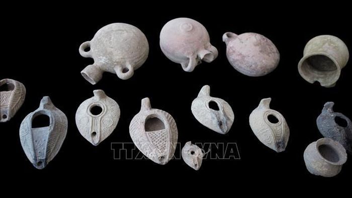 Cuộc khai quật còn phát hiện hàng chục bình và đồ đựng bằng gốm, nhiều đèn dầu còn nguyên vẹn. Ảnh: TTXVN phát