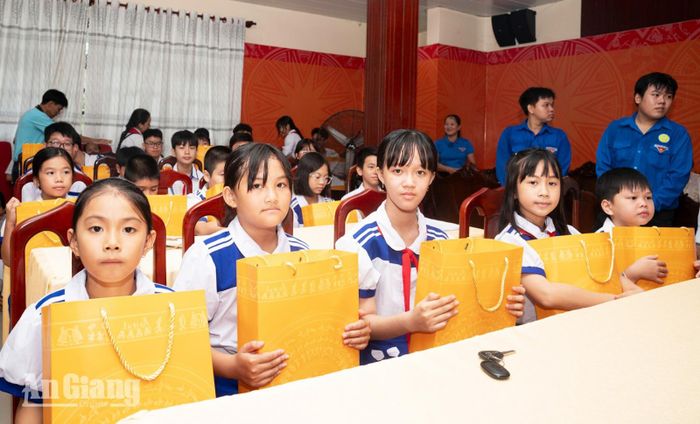 Các học sinh xã Mỹ Hòa Hưng vui mừng khi được nhận quà của Phó Chủ tịch nước Võ Thị Ánh Xuân.