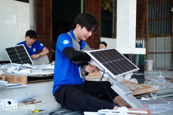 Sinh viên Trường Đại học Văn Hiến lắp đặt đèn năng lượng mặt trời ở ấp Cạnh Đền, xã Vĩnh Phong.