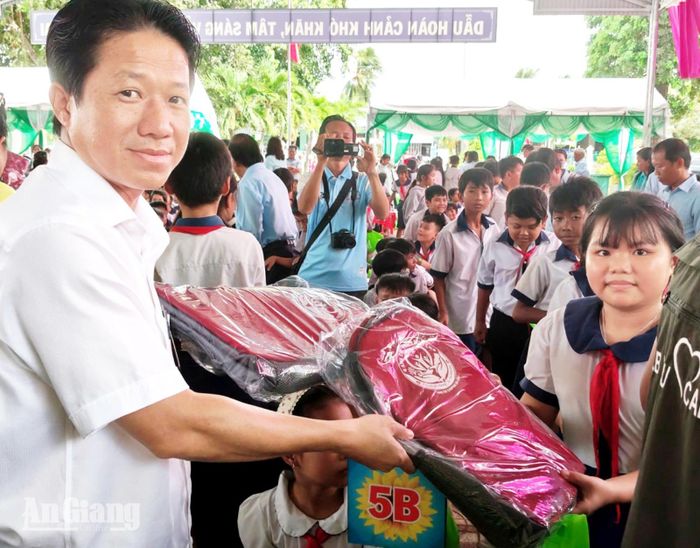 Chủ tịch UBND xã Ba Chúc Võ Thanh Tuấn tặng quà cho các học sinh.